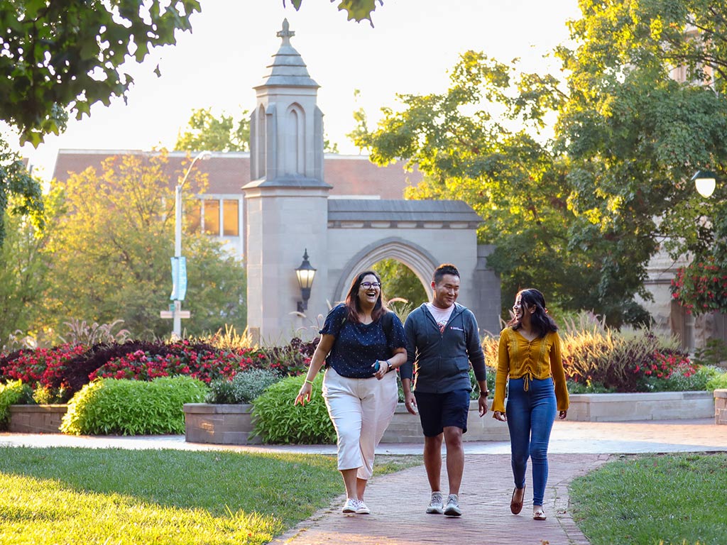 Students walking in front of the Sample Gates